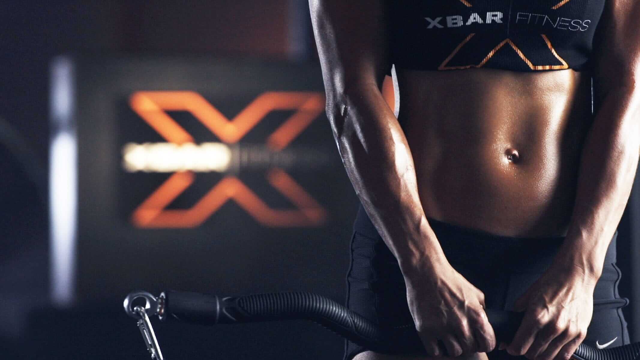Person engaging in xbar workout nutrition training with XBAR Fitness logo in the background.