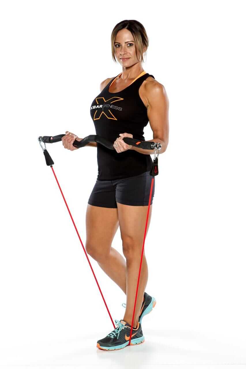 Woman using resistance band workouts for full-body training with XBAR equipment.