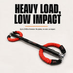A red resistance band with bright red wrapped ends and silver metal hardware, displayed on a light gray background with bold text reading 'HEAVY LOAD, LOW IMPACT'.