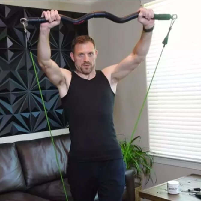 Man exercising with a xbar fitness system in a home setting focusing on chest & tricep workouts, as part of the 75 Day Extreme Workout Program