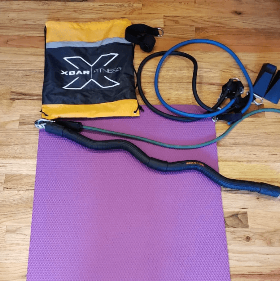 XBar Fitness bag, resistance bands, showing the size against a purple yoga mat on a wooden floor