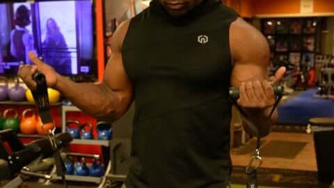 Man exercising using heavy duty handles with resistance bands in a gym setting