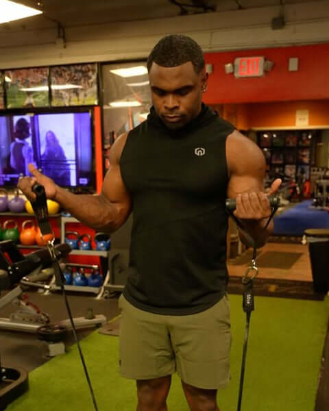 Man exercising using heavy duty handles with resistance bands in a gym setting