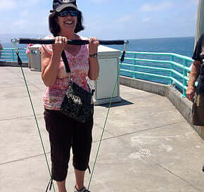 Woman using xbar fitness equipment at the beach